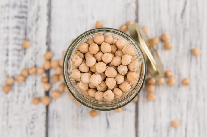 Dried Chickpeas as high detailed close-up shot on a vintage wooden table; selective focus