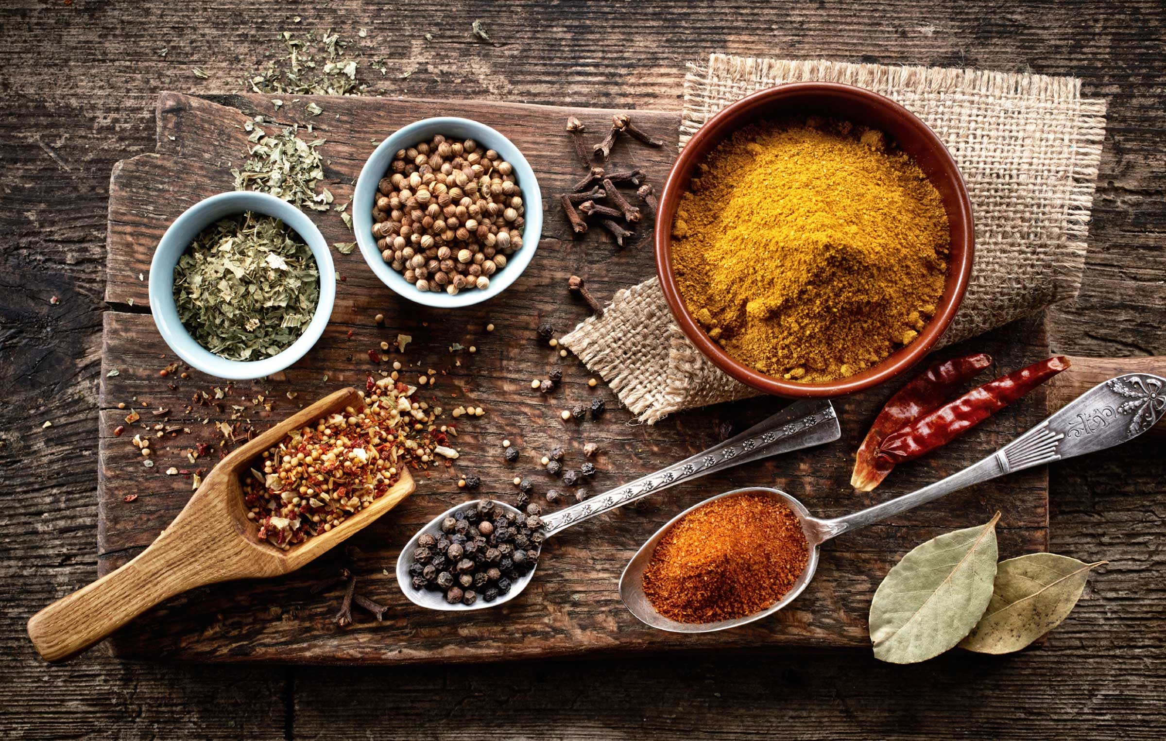 variety of spices on worn wooden cutting board