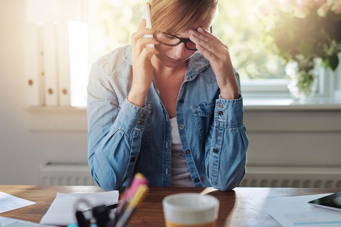 Woman on the phone looking as if stressed.