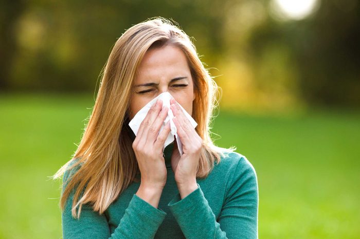 woman outdoors blowing her nose