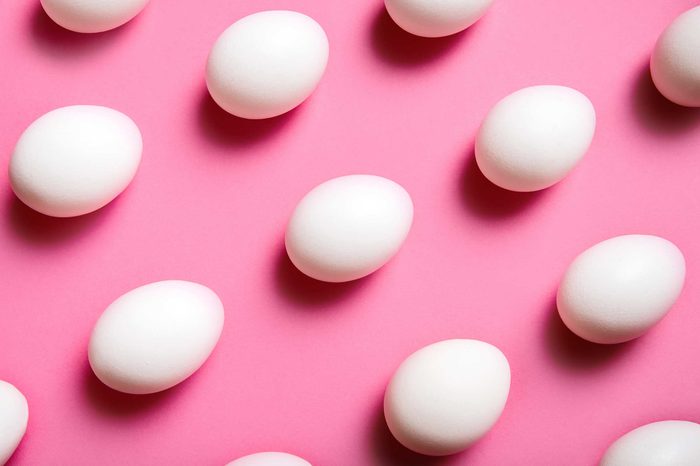 Rows of eggs on a pink background.