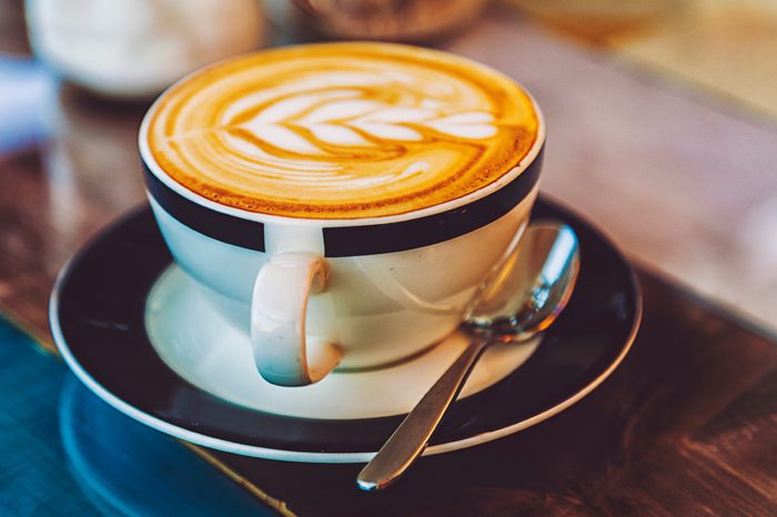 Cup of coffee on a saucer with a spoon.