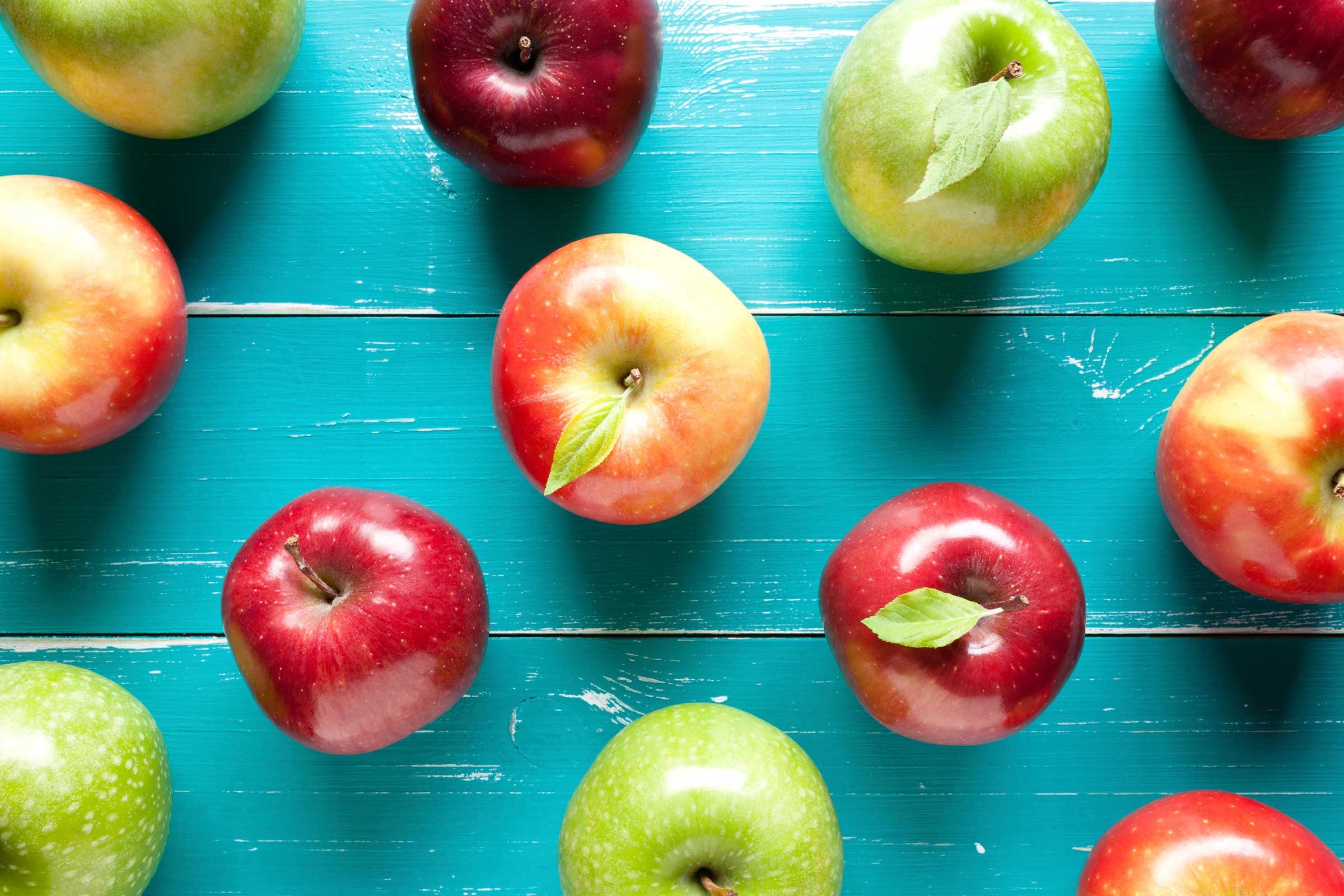 assorted apples on a teal table