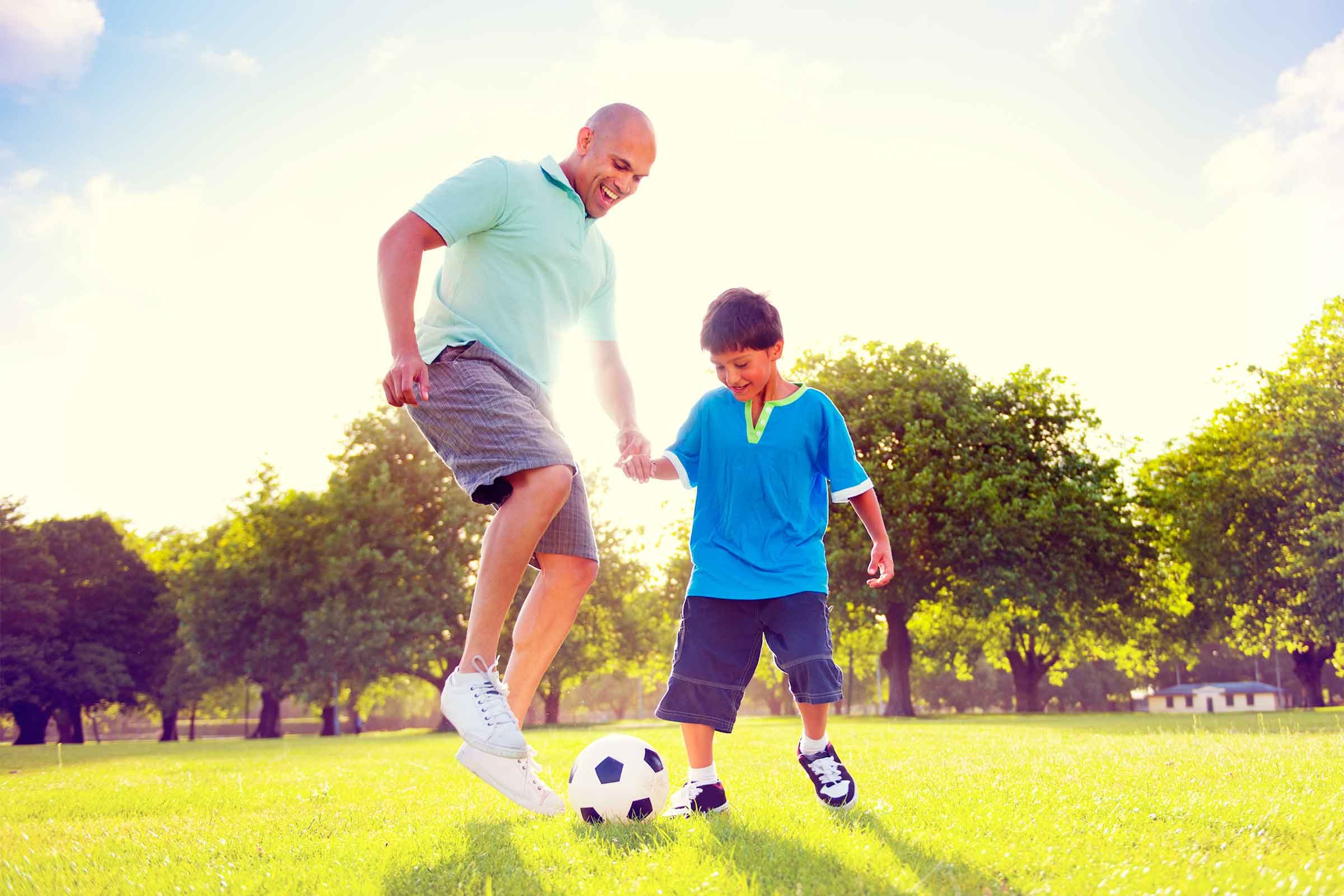 father and son playing soccer