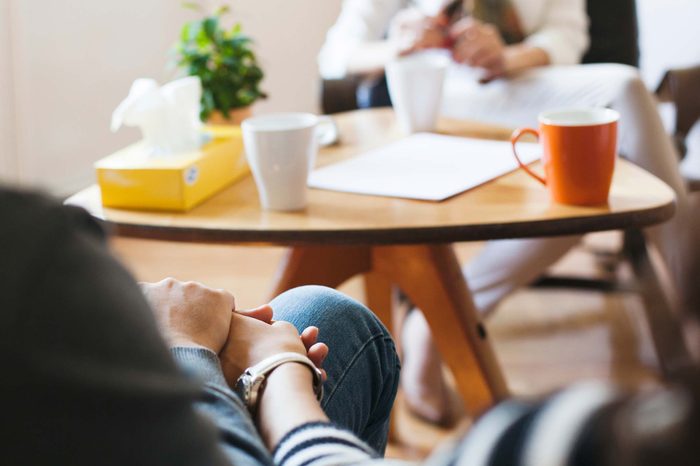 Woman sitting at a table with coffee mugs.