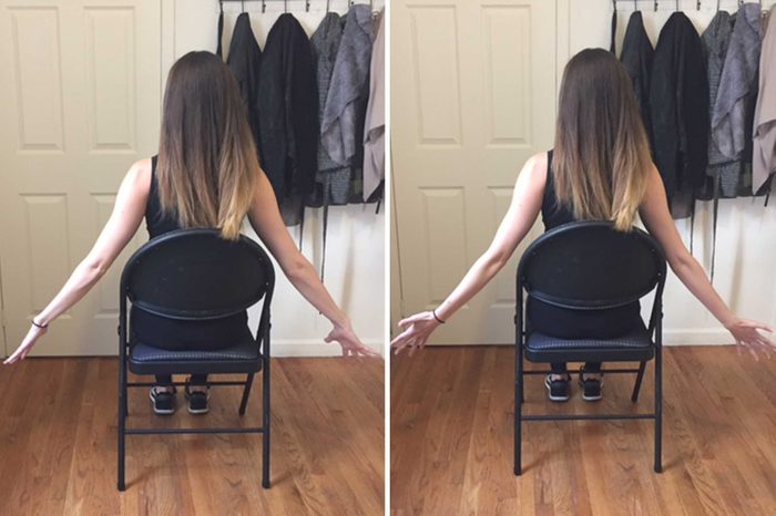 Woman seated in a chair doing arm stretches.