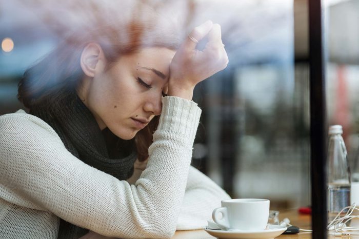 Stressed out woman putting a hand to her forehead