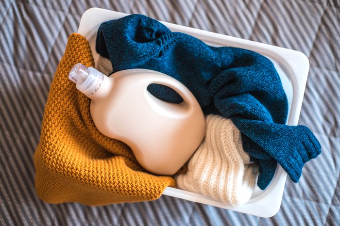 hamper with clothes and laundry detergent