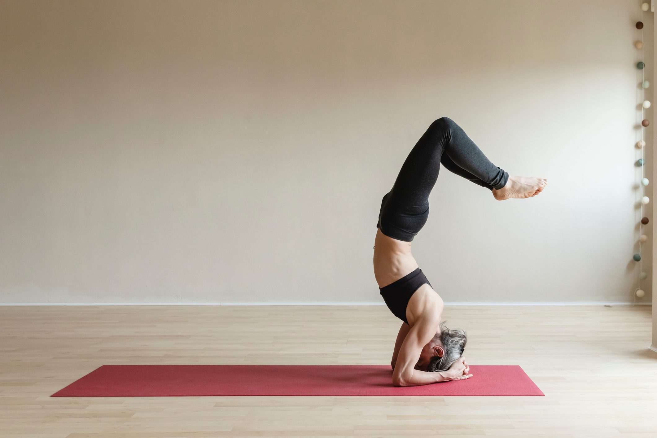 woman doing yoga headstand at home