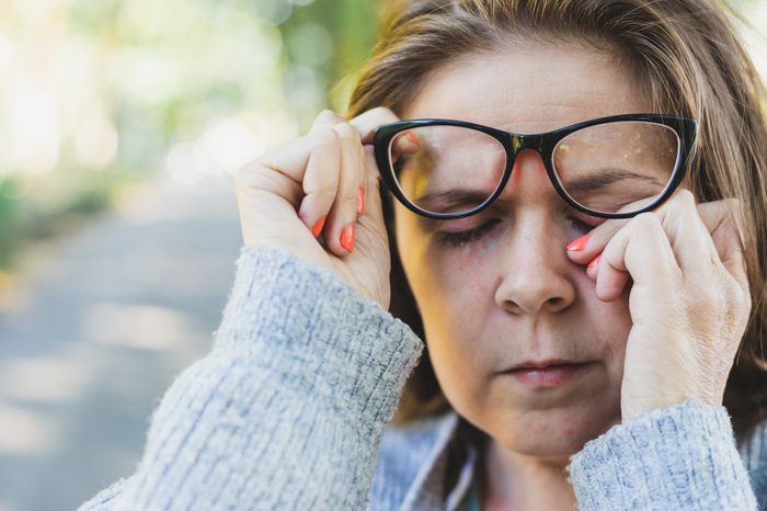 woman rubbing her eye