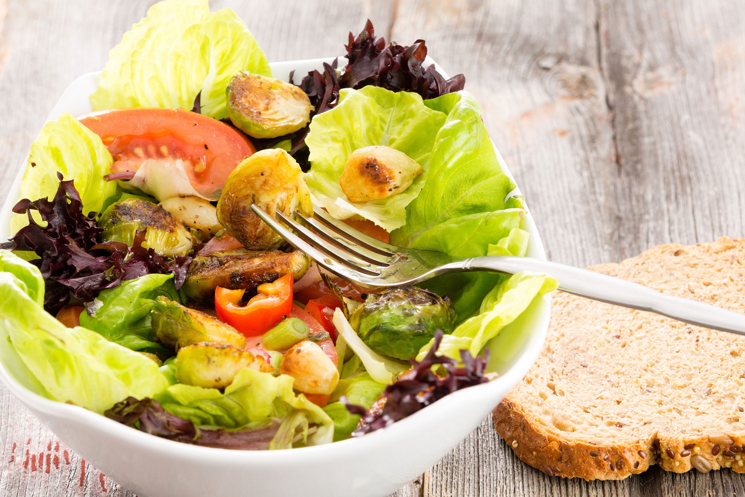 salad with tomatoes and bell peppers; whole grain bread on the side