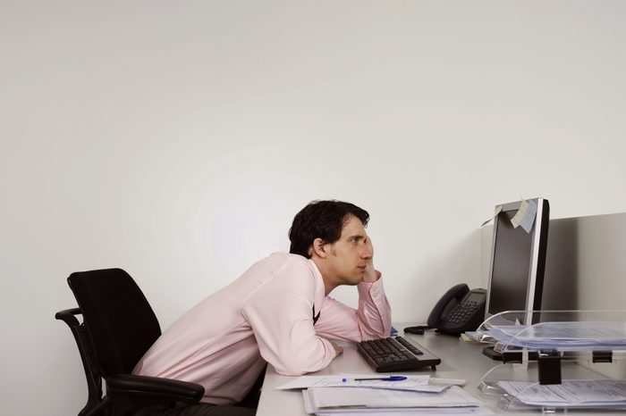 man slouching at work desk