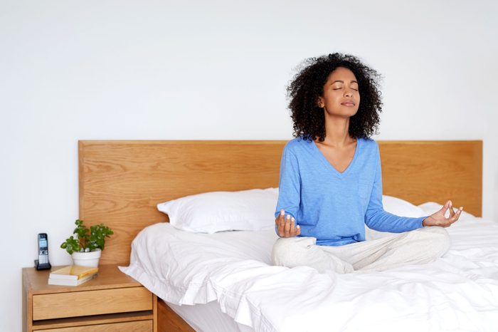 woman meditating in bed 