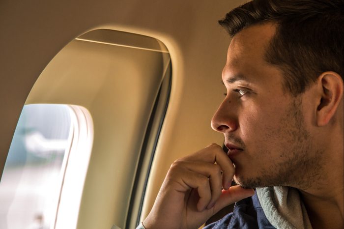 man looking out airplane window