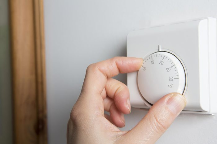 hand on thermostat