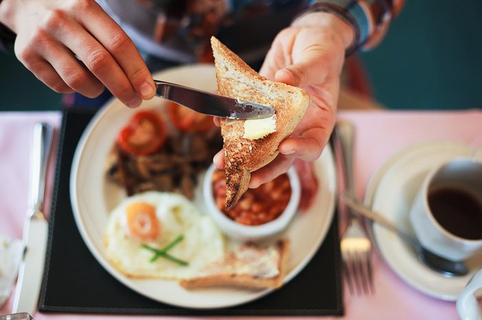 person buttering toast for breakfast