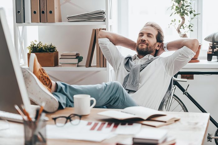 man leaning back in office chair