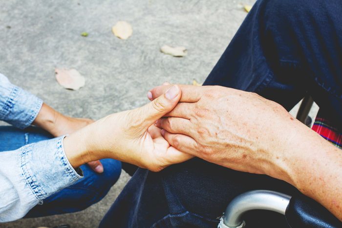 Younger hand holding older hand