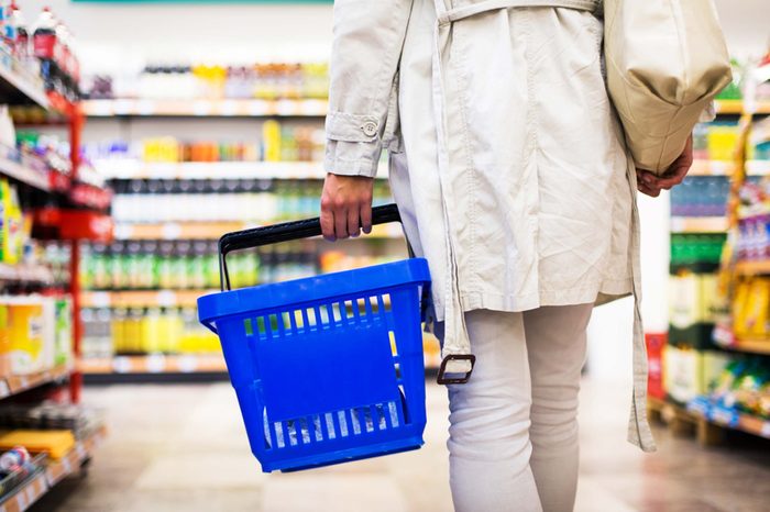 woman carrying basket in grocery store