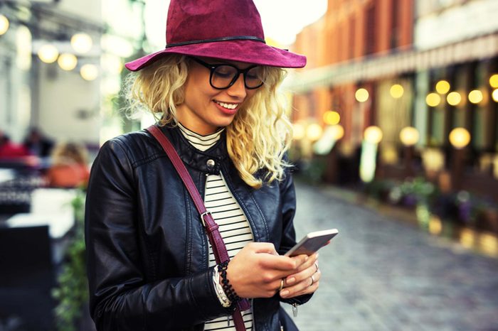 woman in hat texting on phone