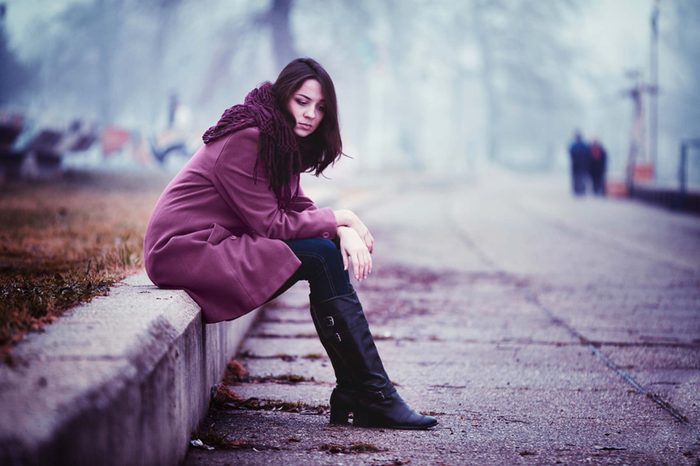 Sad woman sitting outside