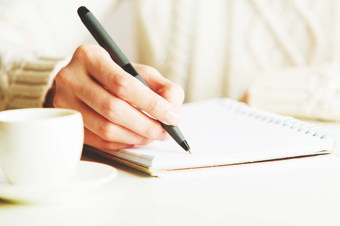 person writing in journal