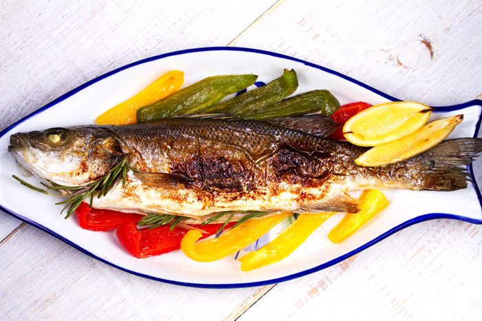 cooked fish on a serving platter with bell peppers