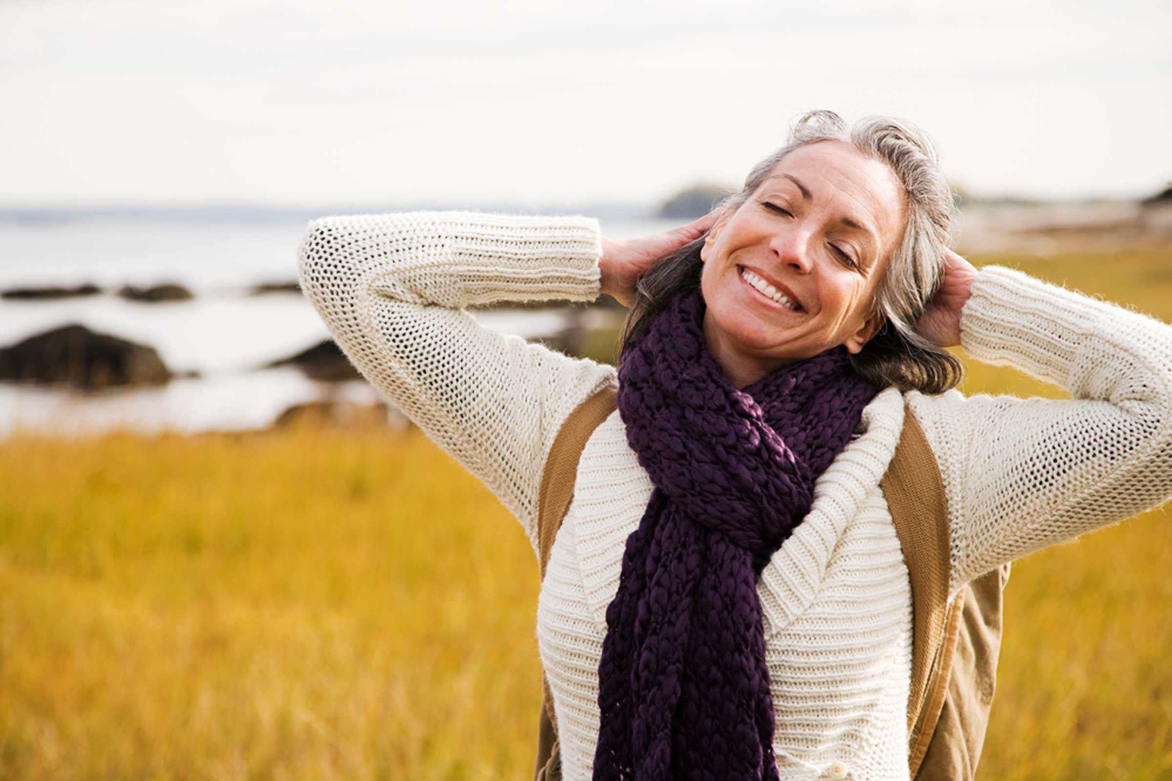 older woman smiling at the shore