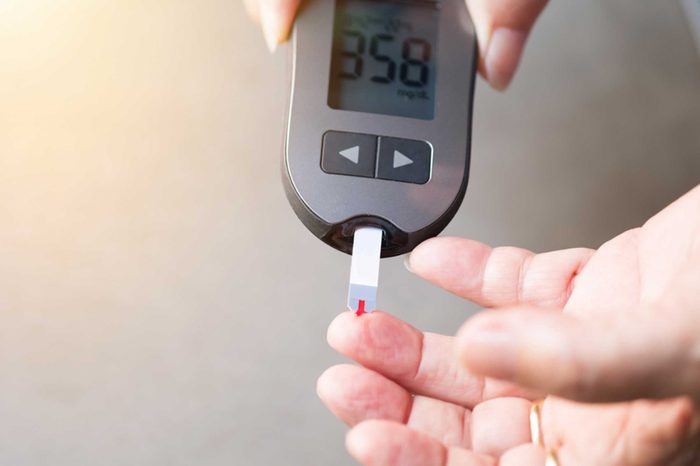 Person checking their blood sugar with a glucose meter.