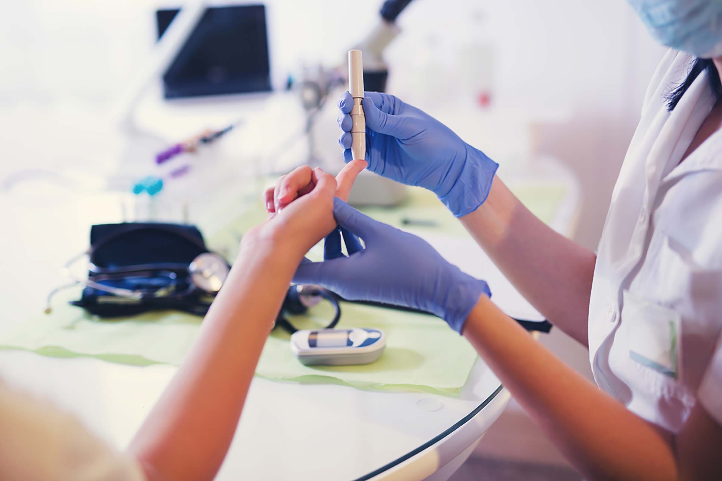 doctor performing a needle stick on a patient's index finger