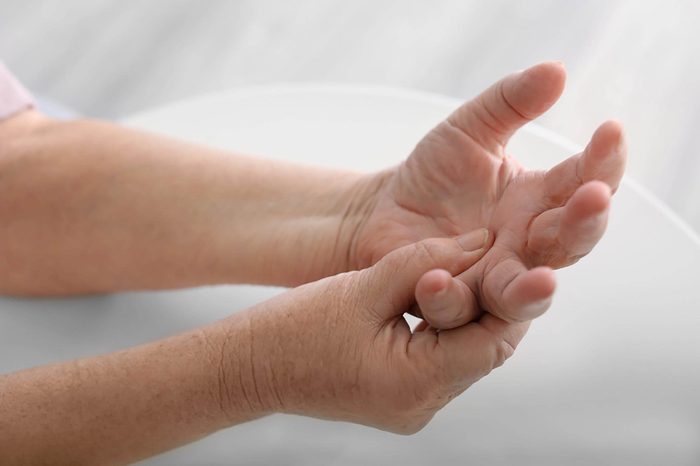 woman massaging her palm with other hand