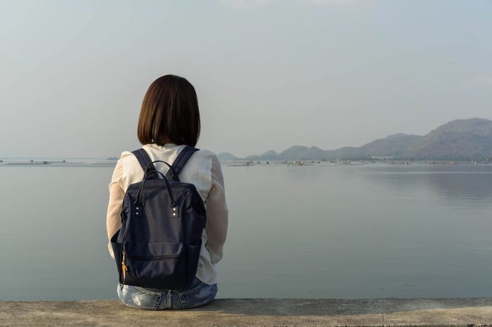 Behind the backpack Asian women on the Krasiew dam ,Dan chang Suphan Buri Thailand