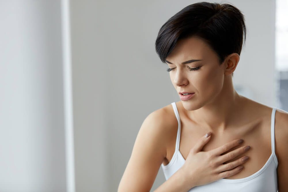 Woman In Pain. Beautiful Young Female Feeling Sharp Strong Pain In Chest. Girl Suffering From Painful Lung Feeling Or Having Heart Attack, Holding Hand On Chest. Health Care Concept. High Resolution