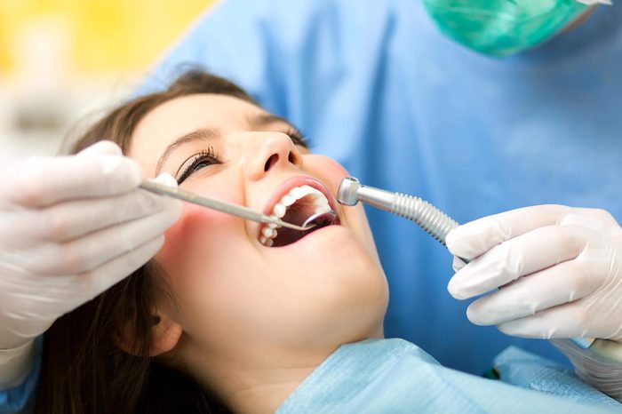 Dentist examining a female patient's mouth