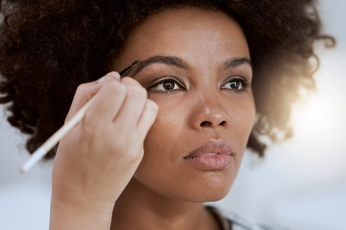 thinning eyebrows woman filling in her eyebrows