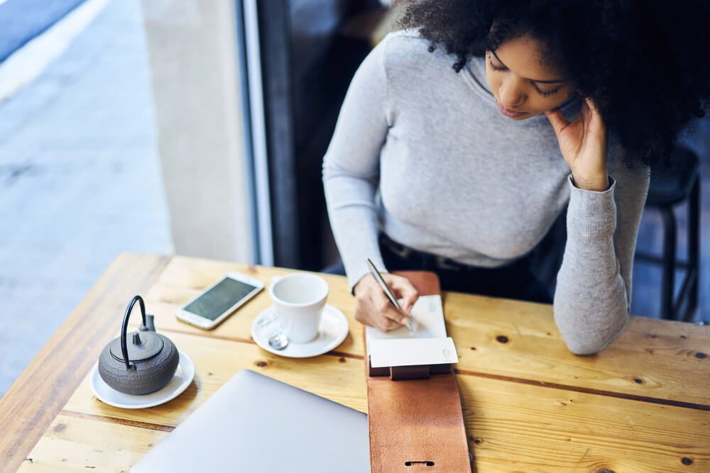 woman writing in a journal or a to-do list