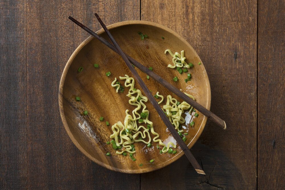 bowl with some leftover noodles with chopsticks 