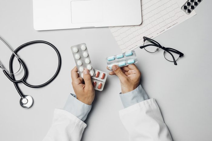 Male doctor holding pills