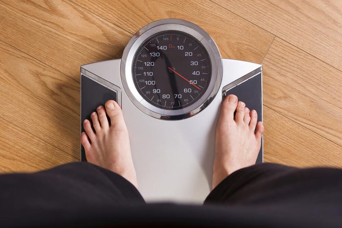 Person weighing himself on a scale