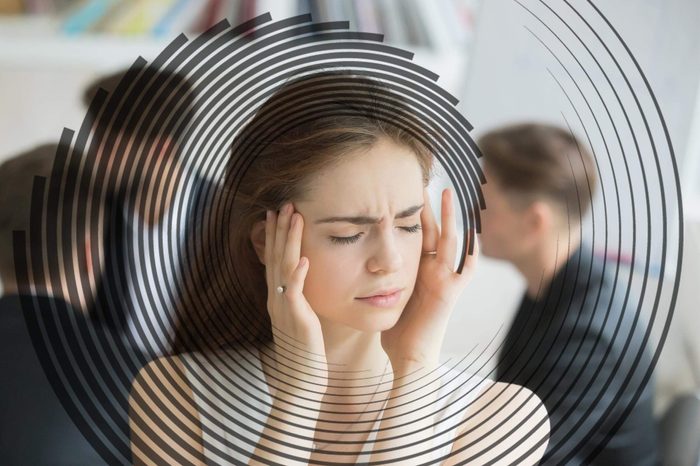 woman with eyes closed, hands at her head