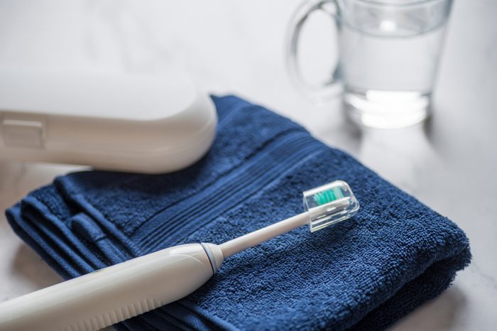 Ultrasonic electric vibration toothbrush on a blue towel.