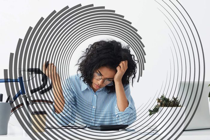 woman with head tilted into her hand staring at her desk