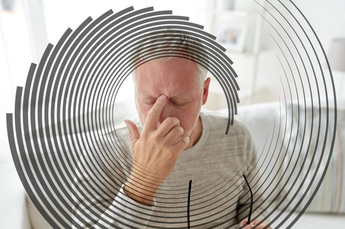 elderly man holding his index finer to the bridge of his nose