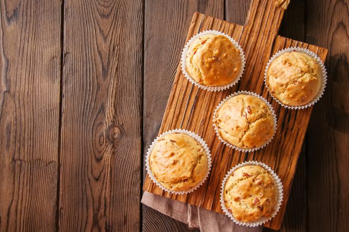 Homemade muffins with bacon and cheese on a wooden cutting board