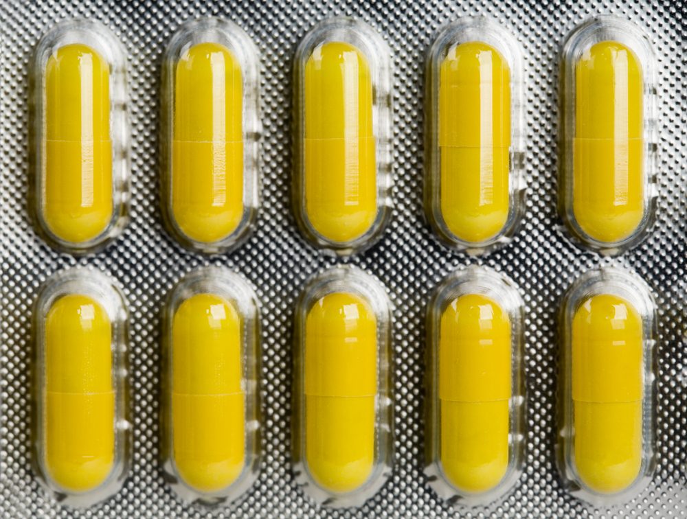 Packing of yellow medical pills background.