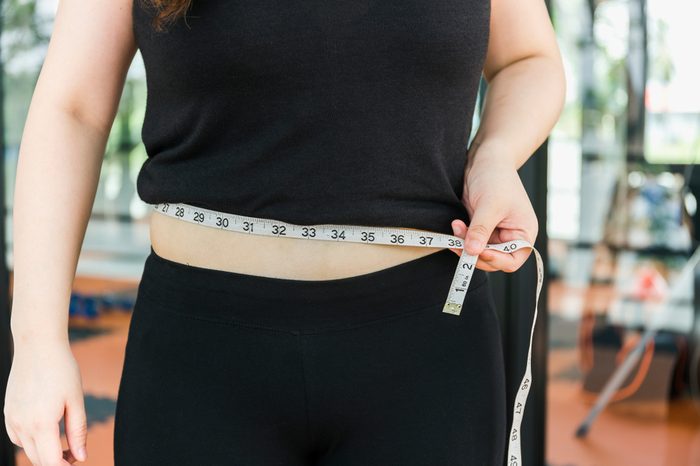 woman with measuring tape around her stomach