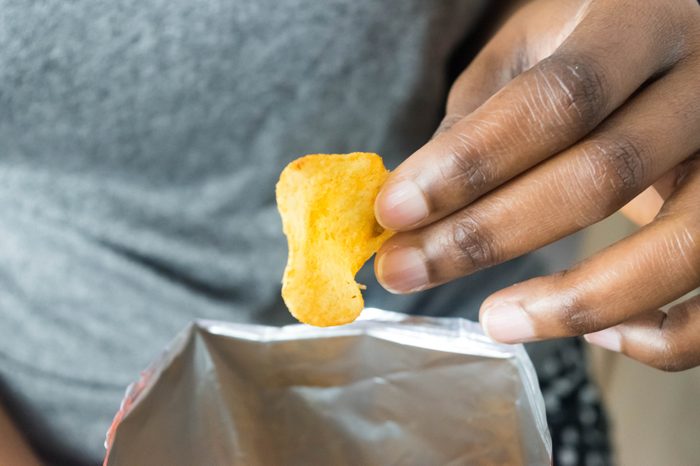 A man eating potato chips from bag