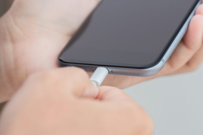 close up hand plugging usb cable into smartphone