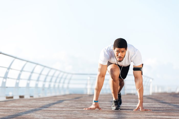 Man in running start position on pier