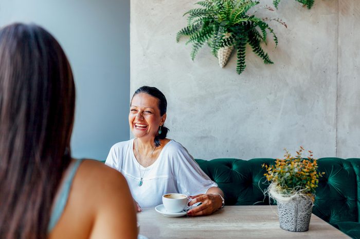 Two happy women talking in cafe. Aged woman and her adult daughter drinking coffee at cafe. Mothers day.